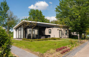 Lodge moderno con terraza cubierta y jardín en el Holiday Resort 't Schuttenbelt, Países Bajos.