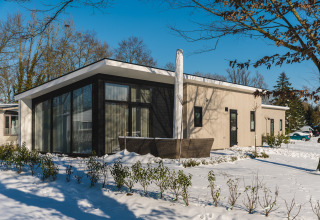 Bos Lodge presso Holiday Resort 't Schuttenbelt nei Paesi Bassi, lodge moderno con ampie vetrate sulla neve.