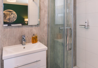 Modernes Badezimmer mit Dusche, Spiegel und Waschbecken in der Bos Lodge, Holiday Resort 't Schuttenbelt, Niederlande.