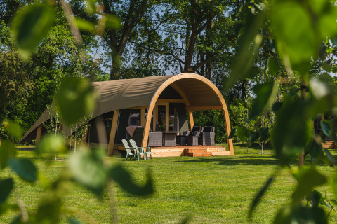 Grande tente safari avec terrasse et mobilier extérieur au Holiday Resort 't Schuttenbelt, Pays-Bas, entourée de nature.