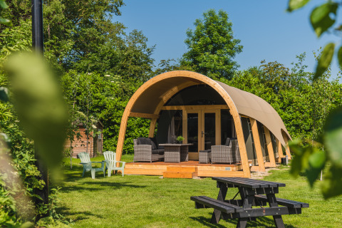 Safari telt Tent lodge XL med sanitære faciliteter på Holiday Resort 't Schuttenbelt, Holland, omgivet af grønne træer.