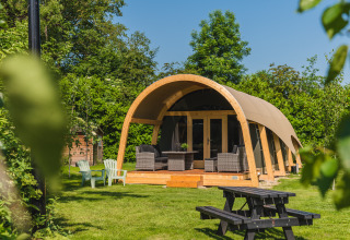 Tenda safari Tent lodge XL con servizi igienici al Holiday Resort 't Schuttenbelt nei Paesi Bassi, circondata dal verde.