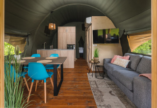 Binnenzicht van een luxe safaritent met leef- en eetruimte in Holiday Resort 't Schuttenbelt, Nederland.