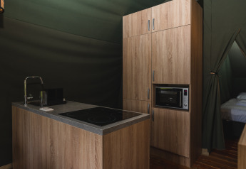 Angolo cottura moderno con mobili in legno in una tenda safari presso Holiday Resort 't Schuttenbelt, Paesi Bassi.