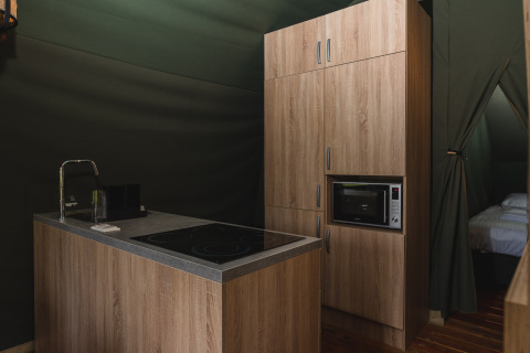 Kitchenette moderne avec armoires en bois, à l'intérieur d'une tente safari au Holiday Resort 't Schuttenbelt, Pays-Bas.