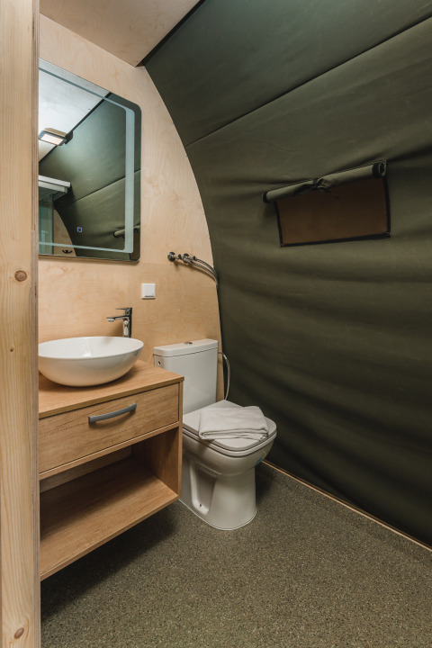 Modernes Bad mit Waschbecken, Spiegel und WC in einem Safarizelt im Holiday Resort 't Schuttenbelt, Niederlande.