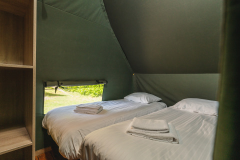 Innenaufnahme eines Safari-Tent Lodge XL mit zwei Einzelbetten im Holiday Resort 't Schuttenbelt, Niederlande.