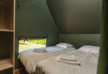 Innenaufnahme eines Safari-Tent Lodge XL mit zwei Einzelbetten im Holiday Resort 't Schuttenbelt, Niederlande.