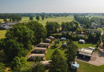 Vue aérienne de tentes safari et de caravanes au Holiday Resort 't Schuttenbelt aux Pays-Bas, entouré de verdure.