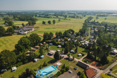 Luftfoto af safari-telt Lodge XL med swimmingpool og grønne marker på ferieparken 't Schuttenbelt, Holland.