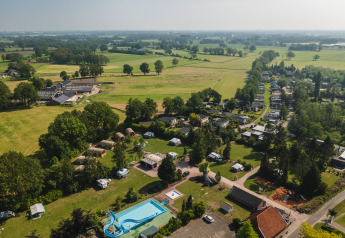 Luftfoto af safari-telt Lodge XL med swimmingpool og grønne marker på ferieparken 't Schuttenbelt, Holland.