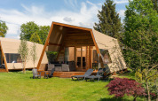 Tienda safari lodge XL con baño en Holiday Resort 't Schuttenbelt en los Países Bajos rodeada de naturaleza.