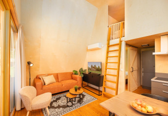 Stylish interior of a safari tent lodge with living area, kitchenette, and loft at Holiday Resort 't Schuttenbelt.