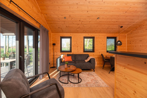 Acogedora cabaña de madera con sala moderna y vista a la terraza en Holiday Resort 't Schuttenbelt, Países Bajos.