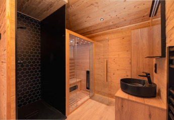 Baño moderno con ducha negra, sauna y lavabo negro en Terrace Lodge, Holiday Resort ’t Schuttenbelt, Países Bajos.