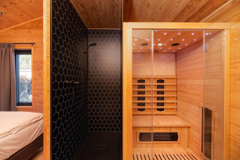 Lodge moderne avec chambre, douche noire et sauna en bois au Holiday Resort 't Schuttenbelt, Pays-Bas.