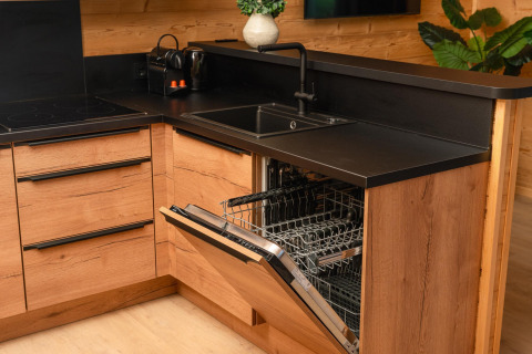 Modern kitchen at Terrace Lodge, Holiday Resort 't Schuttenbelt, Netherlands, with dishwasher and wood finish.