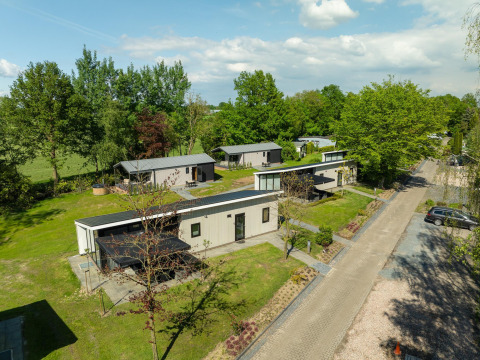 Luftfoto af Terrace Lodge med sauna og spabad på Holiday Resort 't Schuttenbelt i Holland omgivet af træer.