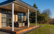 Lodge moderno con terraza de madera y asientos exteriores en Holiday Resort 't Schuttenbelt, Países Bajos.