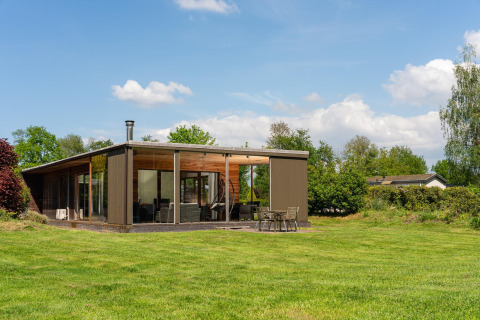 Moderne Woody Lodge Florian ved Holiday Resort 't Schuttenbelt, Holland, omgivet af grøn natur.
