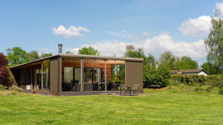 Moderne Woody Lodge Florian op Holiday Resort 't Schuttenbelt, Nederland, te midden van het groen.