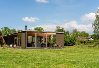 Moderne Woody Lodge Florian op Holiday Resort 't Schuttenbelt, Nederland, omgeven door groen.