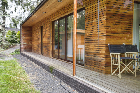 Außenansicht von Woody Lodge Florian im Holiday Resort 't Schuttenbelt, Niederlande, mit Holzverkleidung.