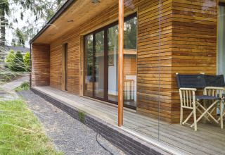 Exterior view of Woody Lodge Florian at Holiday Resort 't Schuttenbelt in the Netherlands with wood siding.