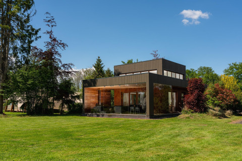 Tiny house moderne Woody Lodge Valerie au Holiday Resort 't Schuttenbelt, Pays-Bas, entourée de verdure.