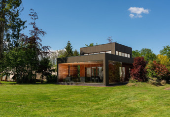 Modern tiny house Woody Lodge Valerie at Holiday Resort 't Schuttenbelt, Netherlands, surrounded by greenery.