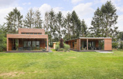 Twee moderne houten tiny houses met grote glaspartijen bij Woody Lodge Valerie in Nederland.