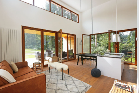 Lichte woonkamer met grote ramen en moderne inrichting in Woody Lodge Valerie op Holiday Resort 't Schuttenbelt.