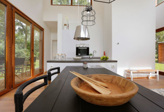 Cucina e zona pranzo luminose della Woody Lodge Valerie al Holiday Resort 't Schuttenbelt nei Paesi Bassi.