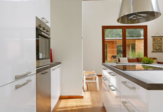 Cocina moderna en Woody Lodge Valerie en Holiday Resort 't Schuttenbelt con grandes ventanas y detalles de madera.