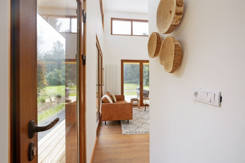Entree van tiny house Woody Lodge Valerie bij Holiday Resort 't Schuttenbelt met zicht op woonkamer en tuin.