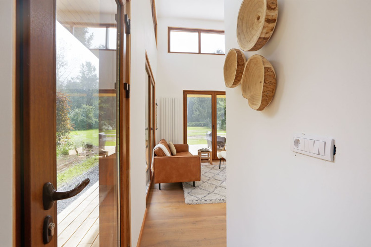 Entrada de la mini casa Woody Lodge Valerie en Holiday Resort 't Schuttenbelt con vista al salón y jardín.