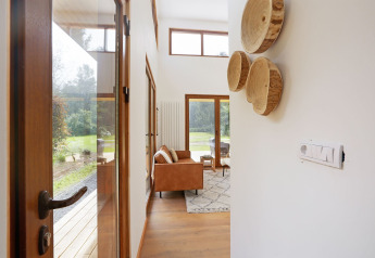 Entree van tiny house Woody Lodge Valerie bij Holiday Resort 't Schuttenbelt met zicht op woonkamer en tuin.