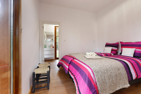 Dormitorio en Woody Lodge Valerie, Holiday Resort 't Schuttenbelt, con ropa de cama colorida y decoración moderna.