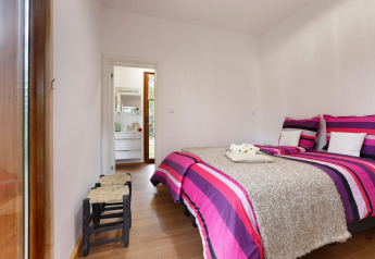 Slaapkamer in Woody Lodge Valerie, vakantiepark 't Schuttenbelt, kleurrige lakens en moderne uitstraling.