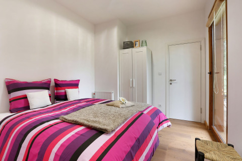 Bedroom at Woody Lodge Valerie, Holiday Resort 't Schuttenbelt, Netherlands, featuring bright striped bedding.