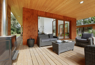 Terraza exterior de Woody Lodge Valerie en el resort 't Schuttenbelt, con modernos muebles de mimbre.