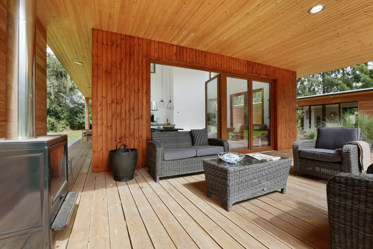 Terraza exterior de Woody Lodge Valerie en el resort 't Schuttenbelt, con modernos muebles de mimbre.