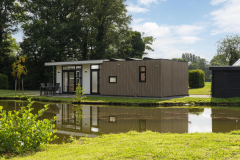Moderne lodge The Water Lily aan een vijver in Holiday Park De Lochemse Berg, Nederland.
