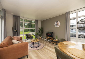 Woonruimte in The Water Lily lodge in Holiday Park De Lochemse Berg, modern ingericht met grote raampartijen.