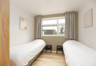 Lichte kamer met twee eenpersoonsbedden en modern interieur in The Water Lily, De Lochemse Berg, Nederland.