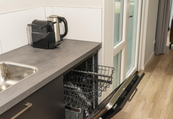 Kleine kitchenette met vaatwasser, koffiezetapparaat en waterkoker in The Water Lily, Holiday Park De Lochemse Berg.