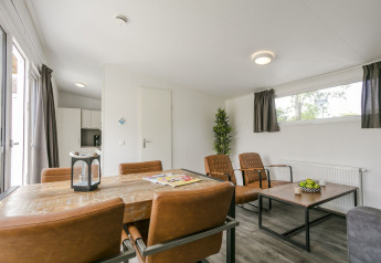 Moderne woon- en eetruimte in Lodge Mistique, vakantiepark De Lochemse Berg, Nederland.