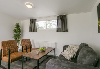 Woonkamer in Lodge Mistique bij Holiday Park De Lochemse Berg met modern meubilair en knusse inrichting.