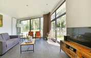 Wohnzimmer der Lodge Grand Modern mit Sauna im Holiday Park De Lochemse Berg, Niederlande, hell und modern.