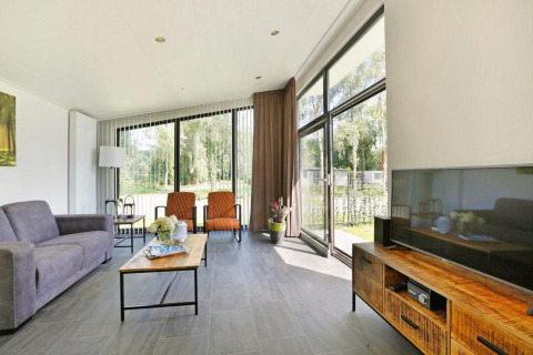 Soggiorno della Lodge Grand Modern con sauna finlandese al Holiday Park De Lochemse Berg nei Paesi Bassi, luminoso e moderno.